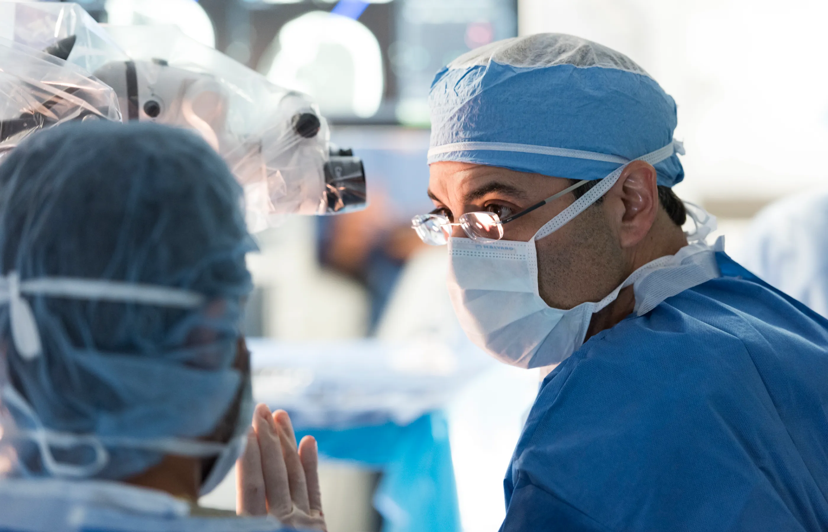 Two Novant Health team members are huddled together talking during surgery.