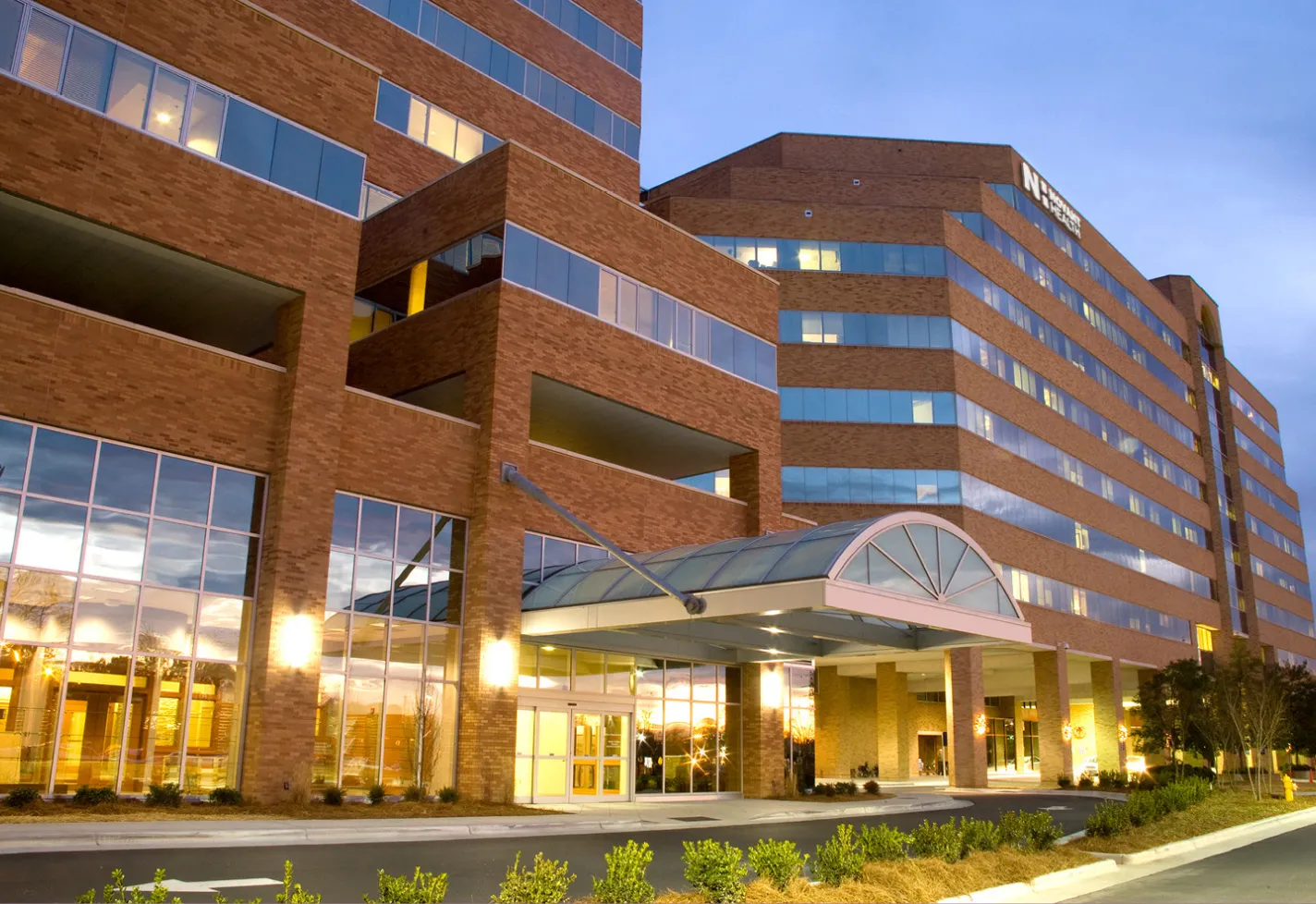 The front entrance of Novant Health Forsyth Medical Center at dusk. 